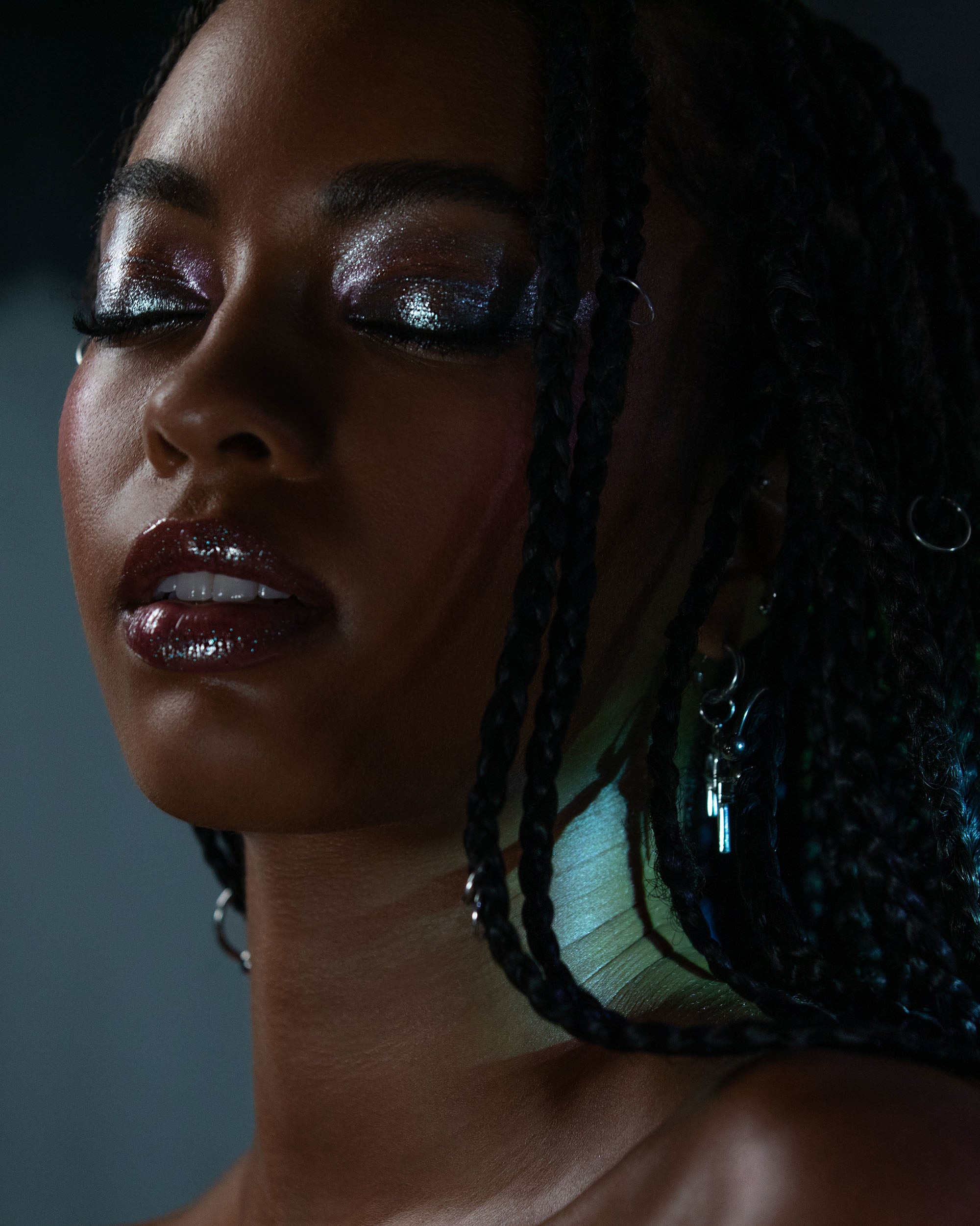 Close-up of a woman with glittery makeup and against a dark background