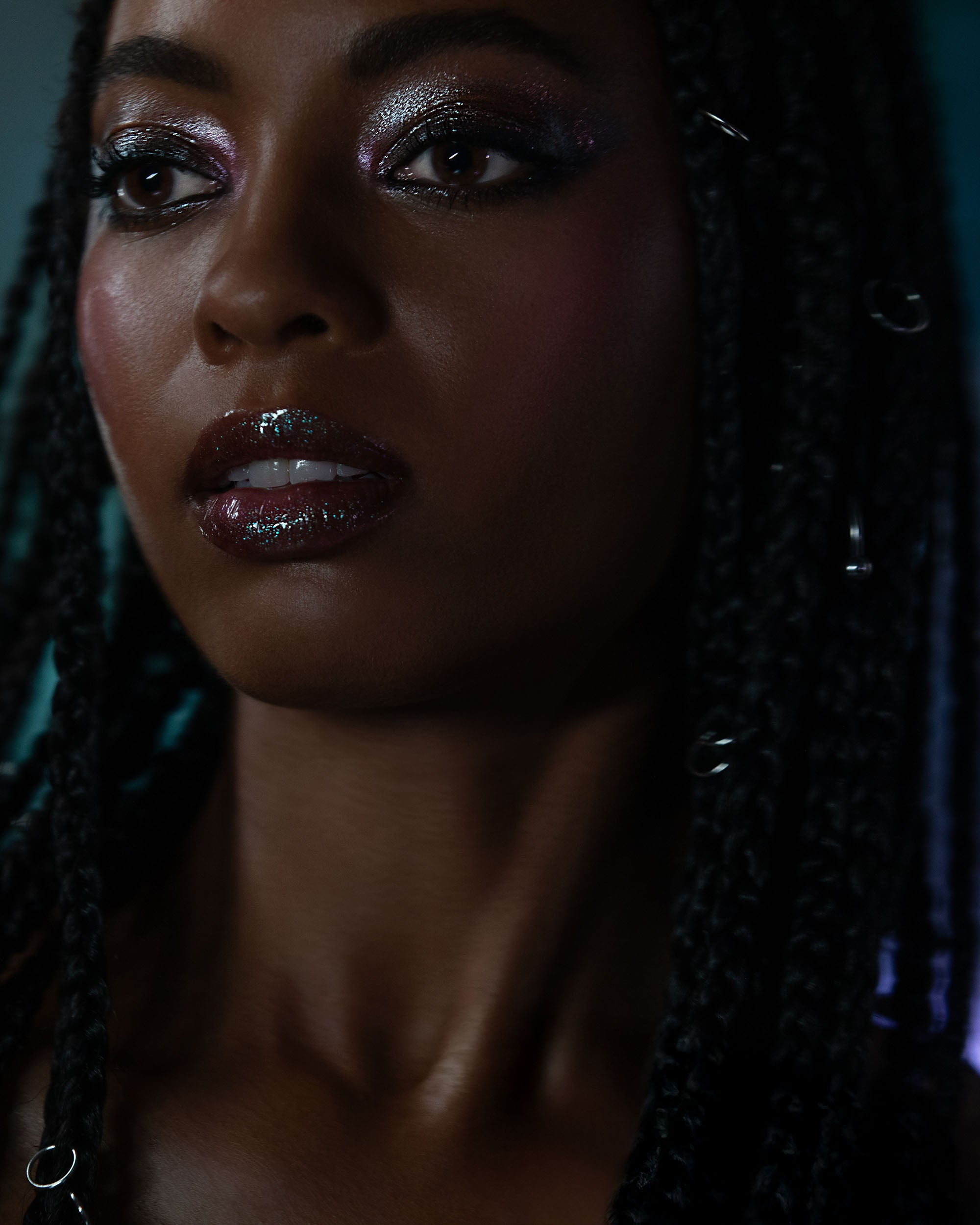 Close-up of a woman with braided hair against a dark background