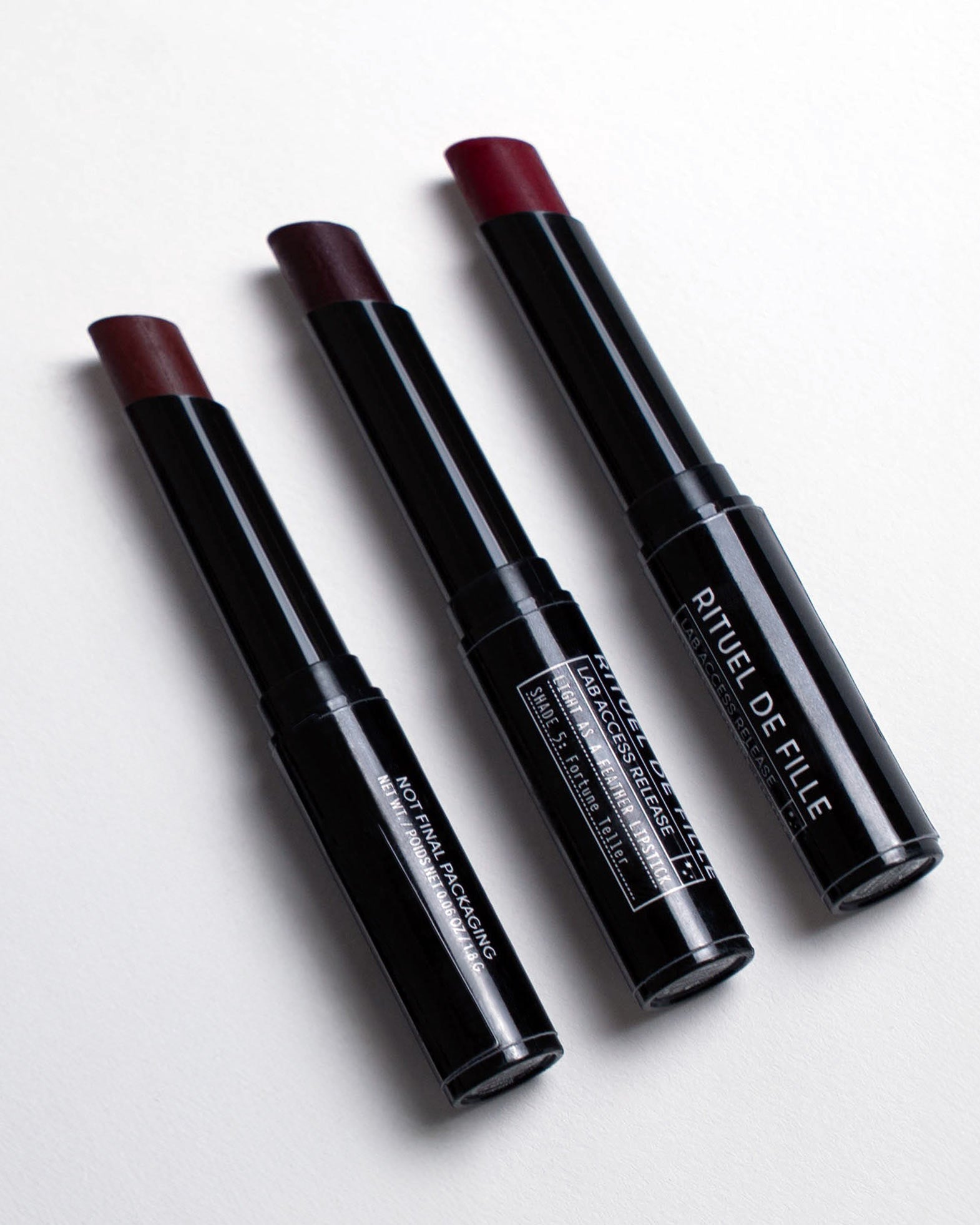 Three red lipsticks on a white background, featuring the brand 'Rituel de Fille'.