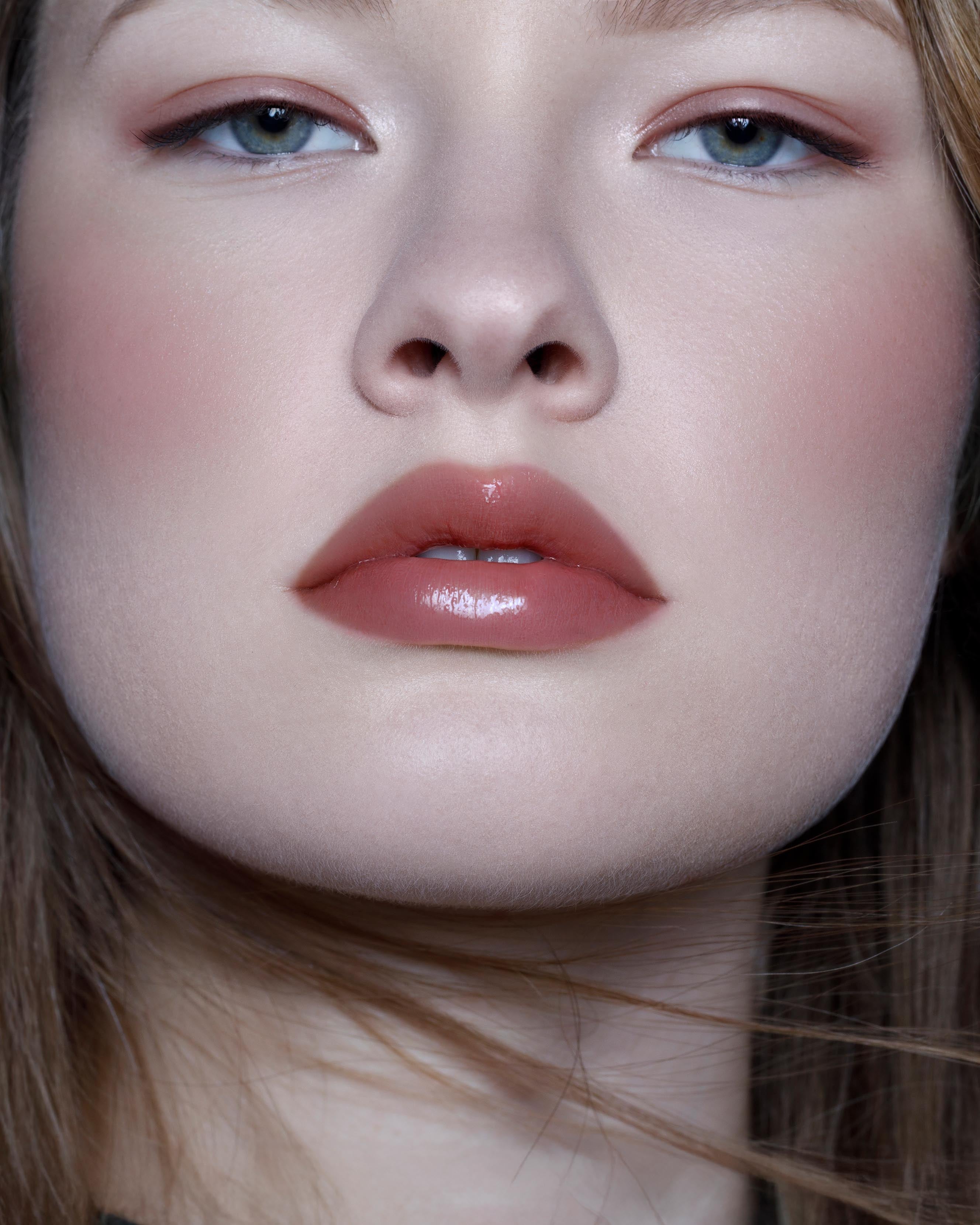 Close-up of a model with fair skin wearing rose pink makeup on lips and cheeks