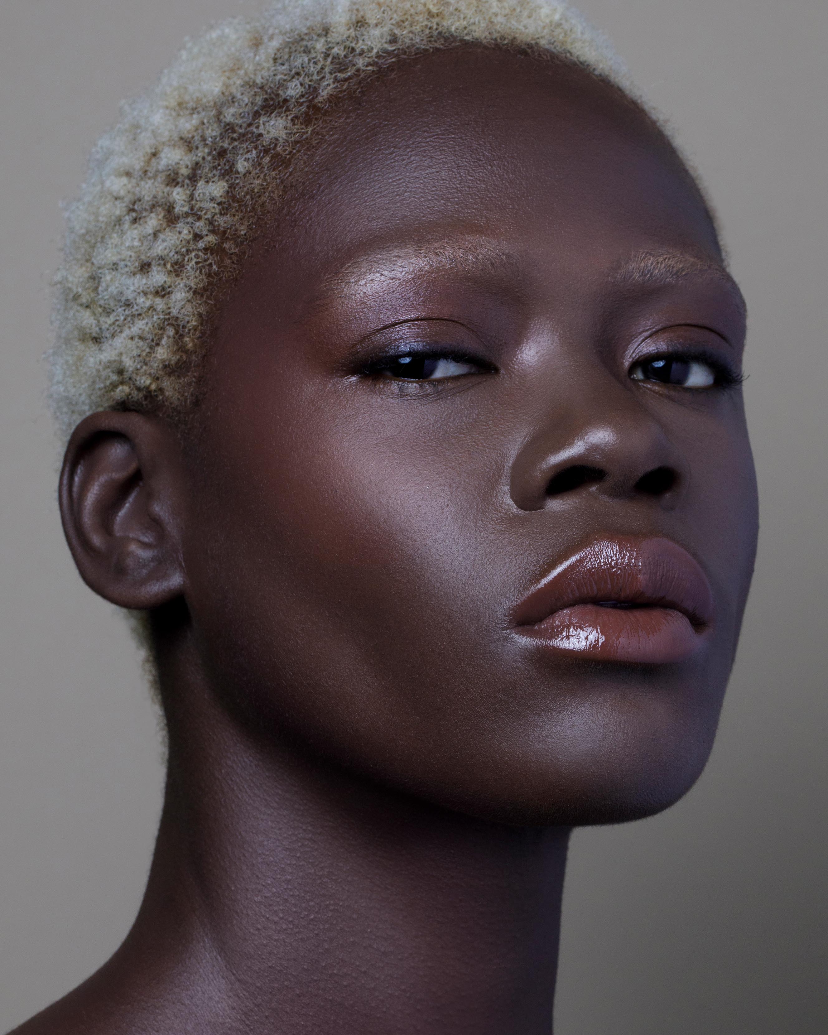 Close-up of a model with deep skin wearing rose pink makeup on lips and cheeks