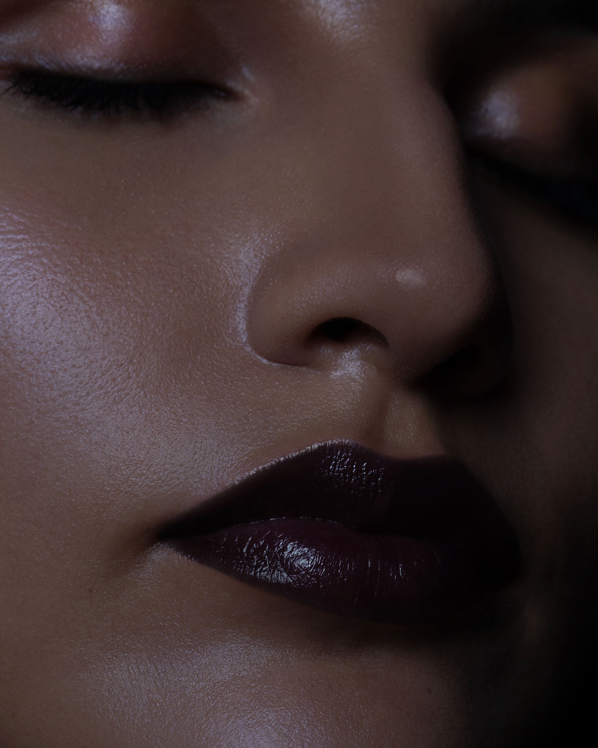 Close-up of a person's lips and nose with a dark background