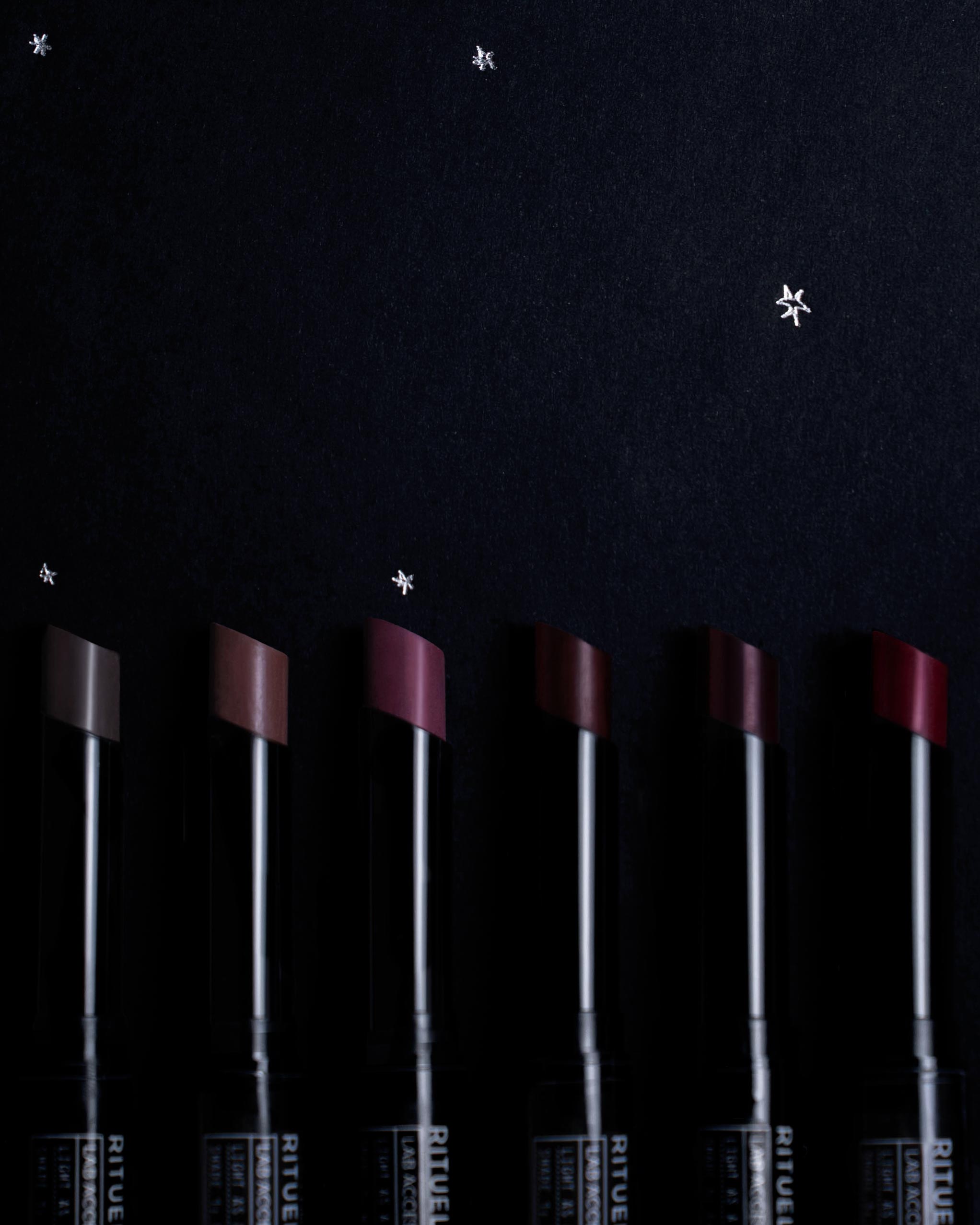 Set of Rituel de Fille lipsticks on a dark background with silver hand-drawn stars