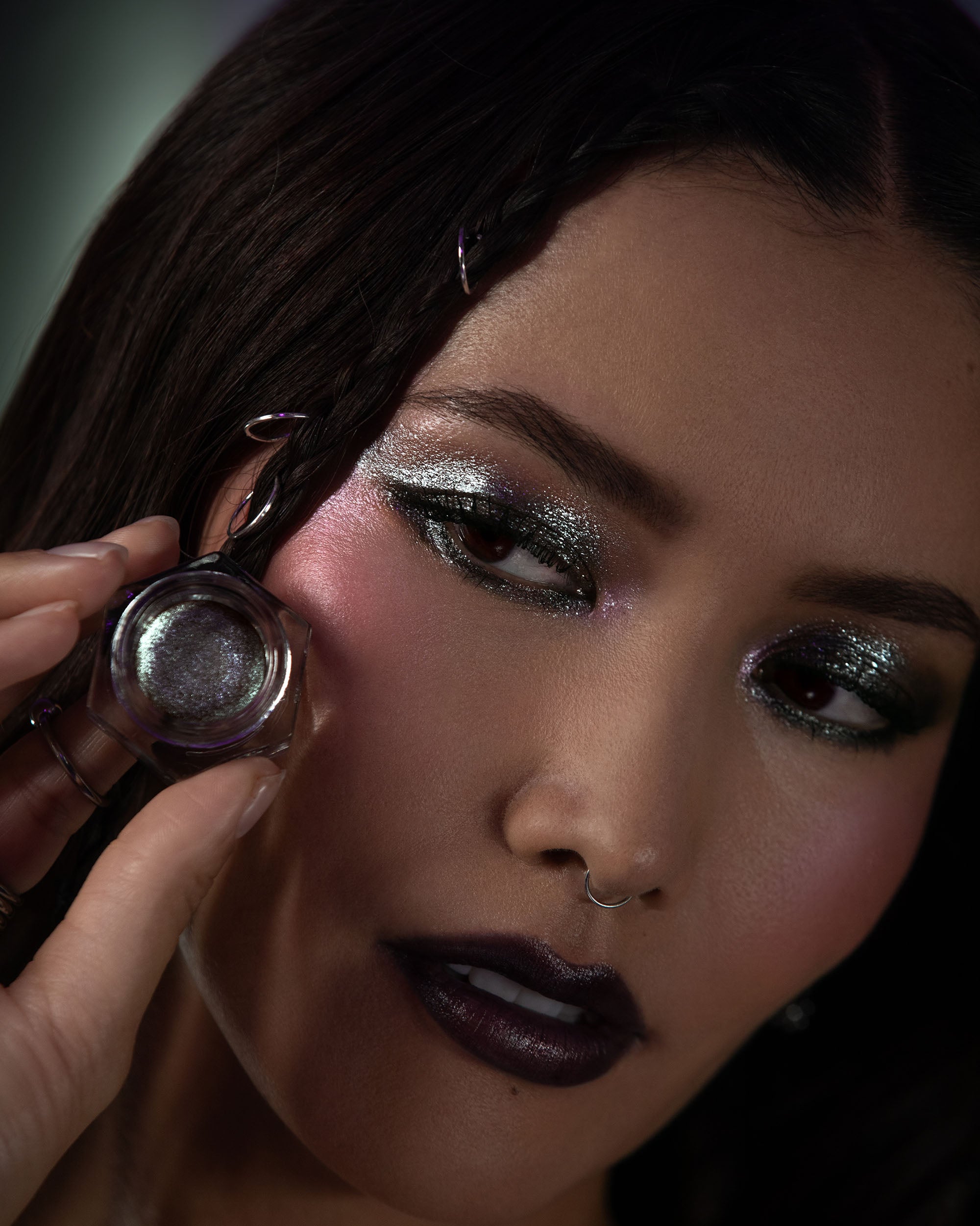 Close-up of a person applying glittery makeup to their eyelid.