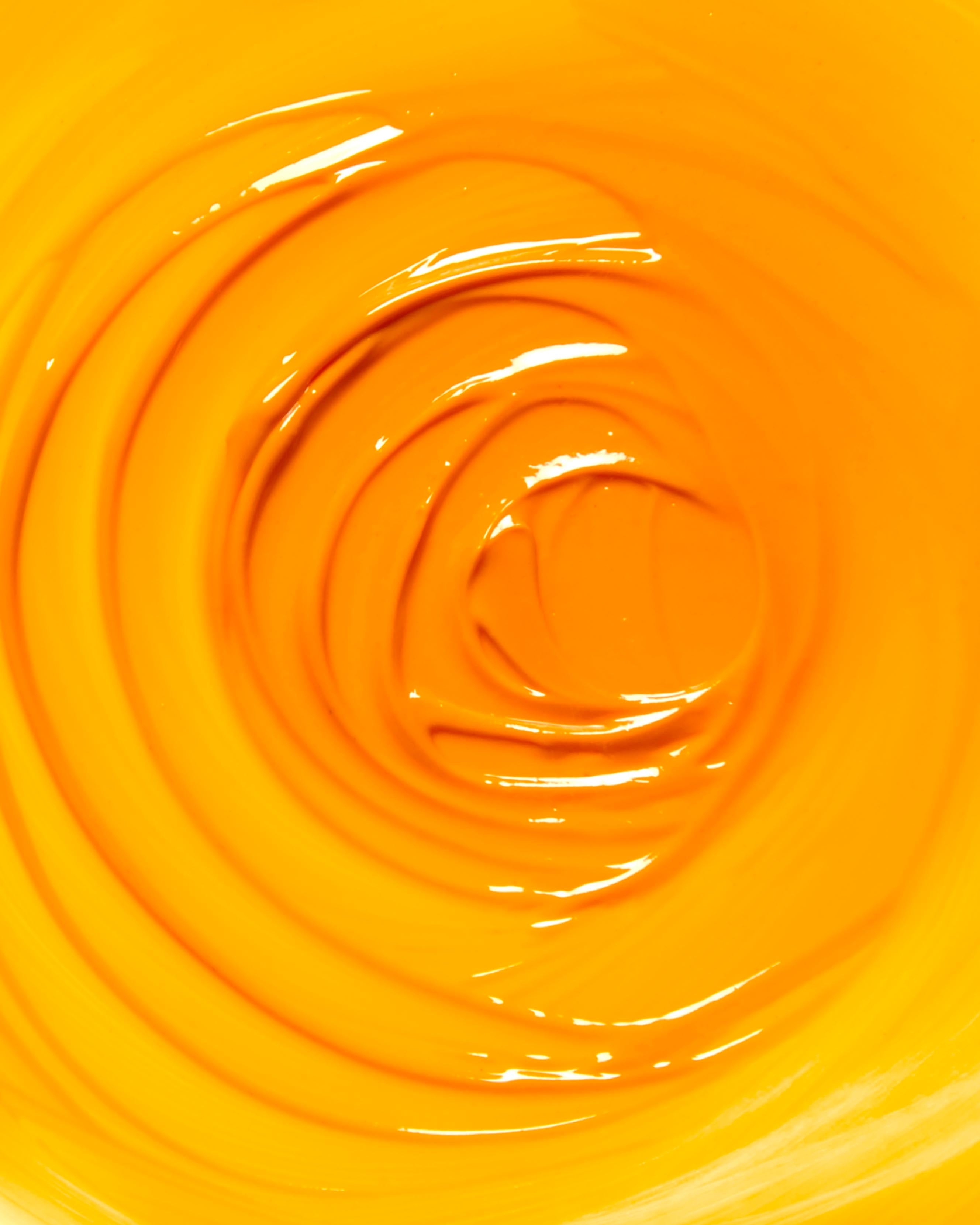 Close-up of bright yellow makeup swirled in a circular pattern